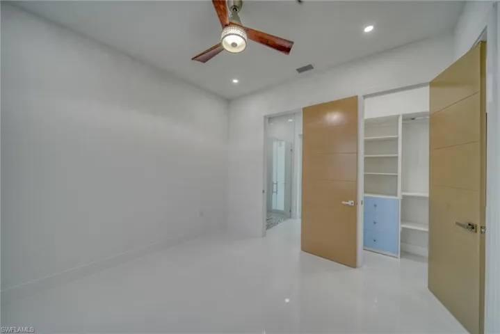 Unfurnished bedroom with recessed lighting, a ceiling fan, and a walk in closet