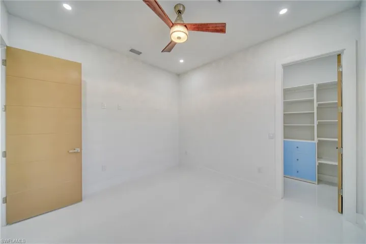 Unfurnished bedroom featuring recessed lighting, a walk in closet, ceiling fan, and a closet