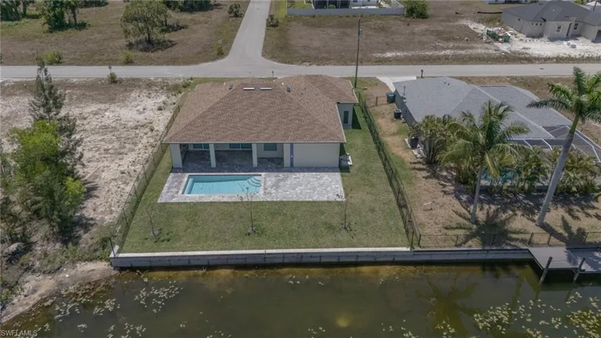 View from above of property with a large body of water and a pool area