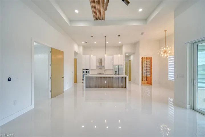 Kitchen featuring modern cabinets, light tile patterned floors, stainless steel appliances, white cabinetry, and a sink
