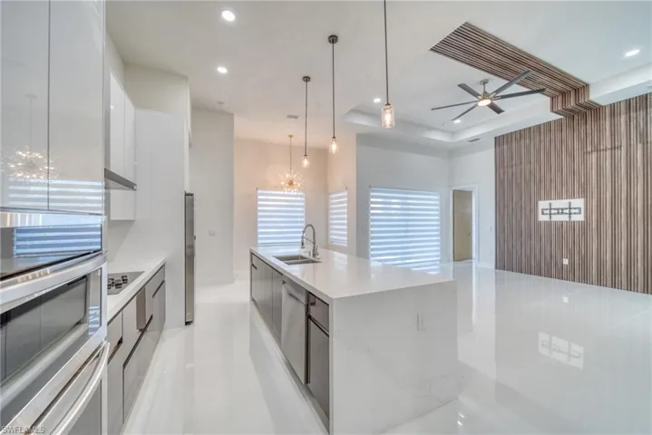 Kitchen with modern cabinets, a sink, stainless steel appliances, white cabinetry, and recessed lighting