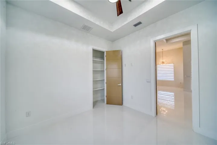 Empty room featuring baseboards, light tile patterned flooring, and a chandelier