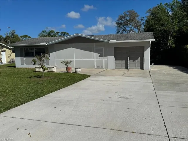 Single story home with concrete driveway, a garage, a front yard, stucco siding, and roof with shingles