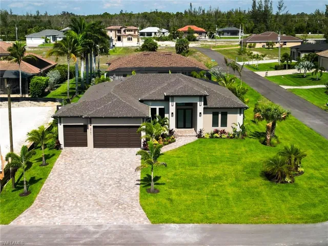 View of front of house with a garage and a front yard