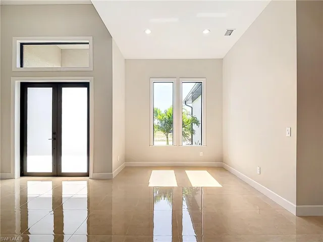 Unfurnished room with french doors and light tile floors