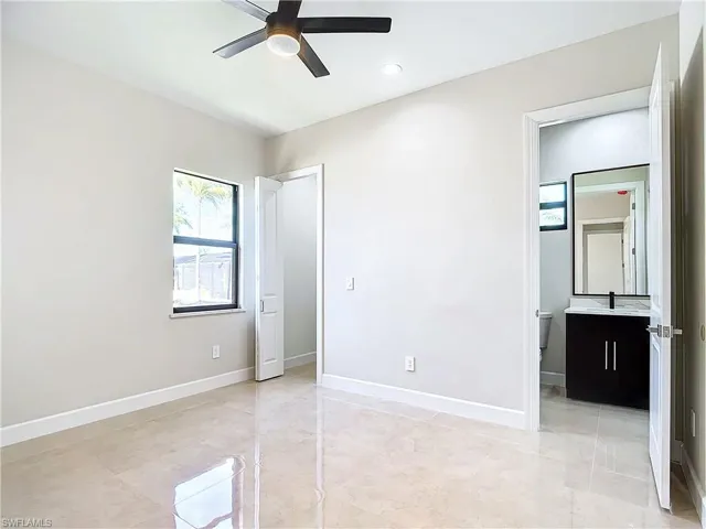 Unfurnished bedroom featuring sink, ceiling fan, and light tile floors