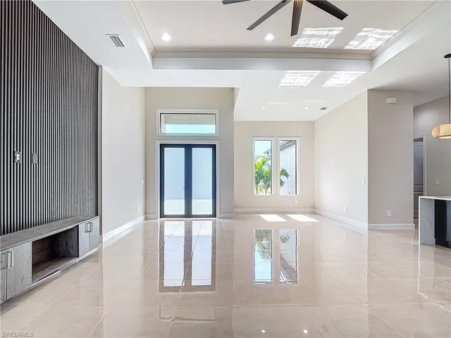 Unfurnished room with ceiling fan and light tile flooring