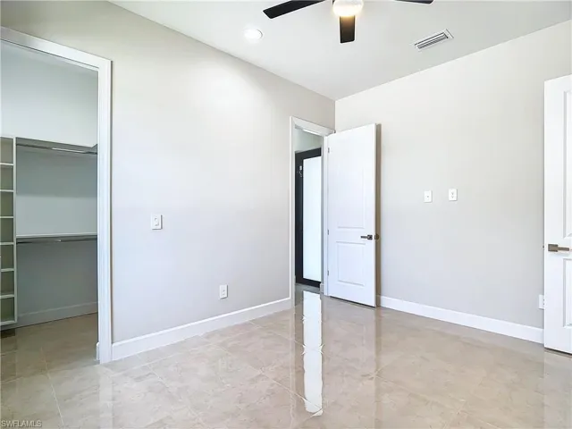 Unfurnished bedroom with a closet, ceiling fan, and light tile floors