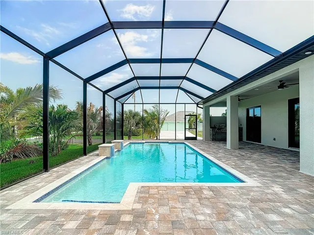 View of swimming pool with a lanai, a patio area, and ceiling fan