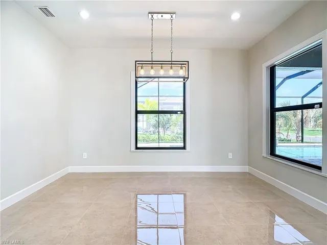 Unfurnished room with a notable chandelier and light tile floors