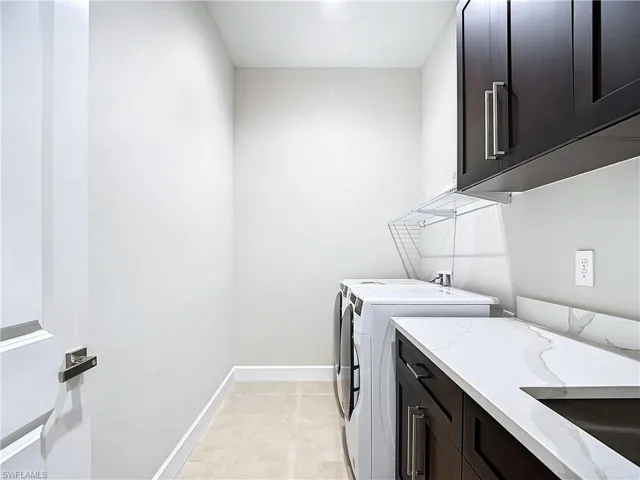 Laundry room with cabinets, independent washer and dryer, washer hookup, sink, and light tile floors