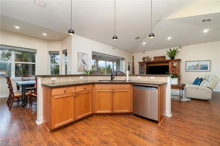 Kitchen with visible vents, dishwasher, dark stone counters, a sink, and open floor plan