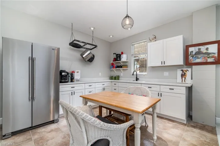 Kitchen featuring high quality fridge, light countertops, white cabinets, and open shelves