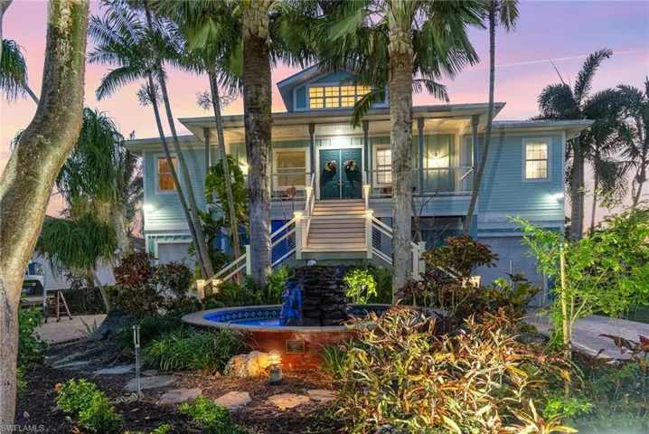 View of front of home featuring a garage, french doors, stairway, and a porch