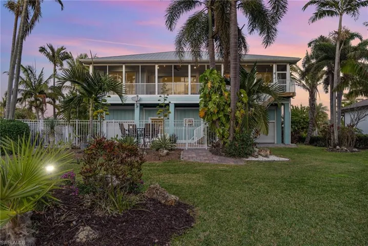 Rear view of house featuring a yard, a sunroom, and fence