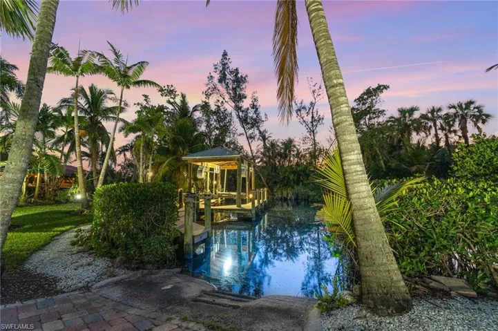Pool at dusk featuring a boat dock