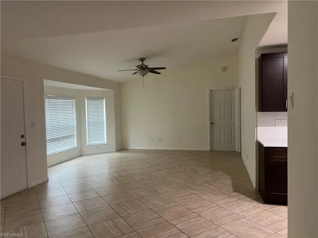 Empty room featuring lofted ceiling and ceiling fan