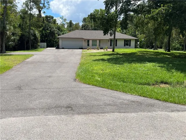 Ranch-style house with a front yard and a garage