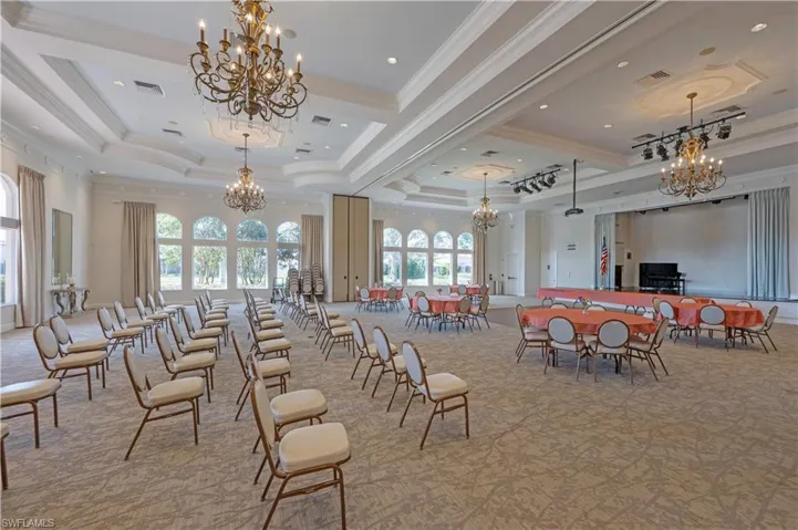 Dining room with suspended lighting, light colored carpet, crown molding, and a tray ceiling