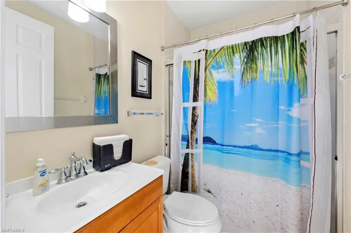 Bathroom featuring a shower with curtain and vanity