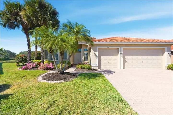 Single story home featuring decorative driveway, an attached garage, a front lawn, stucco siding, and a tiled roof