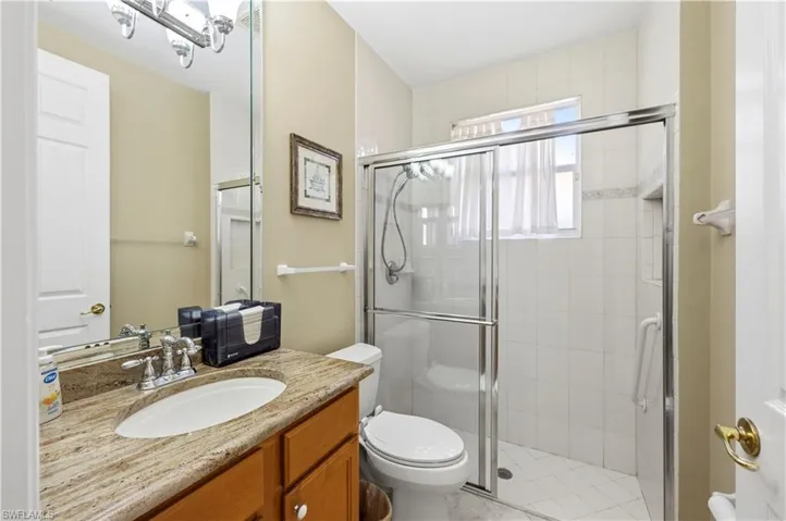 Full bath with a shower stall and vanity
