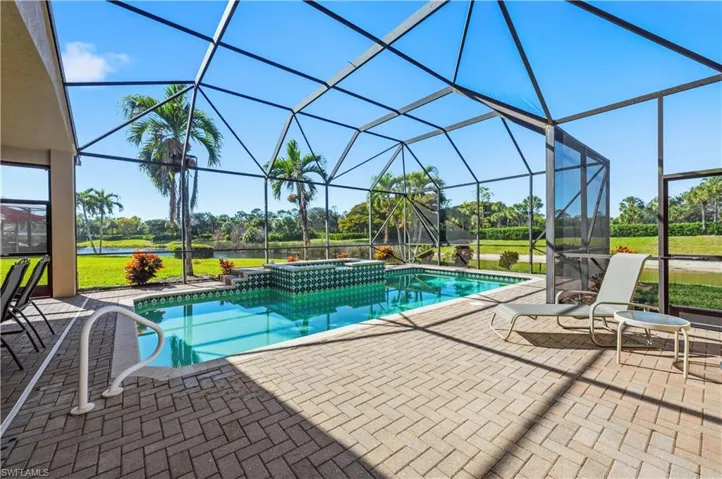 Integrated pool / spa featuring glass enclosure, a sunroom, a patio area, and a water view