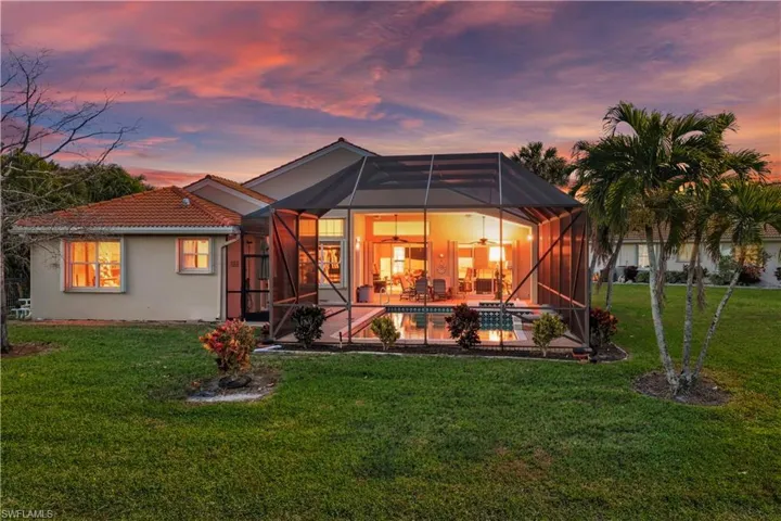Rear view of house featuring a sunroom, a yard, glass enclosure, and an outdoor pool