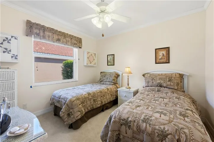 Carpeted bedroom featuring ornamental molding and a ceiling fan
