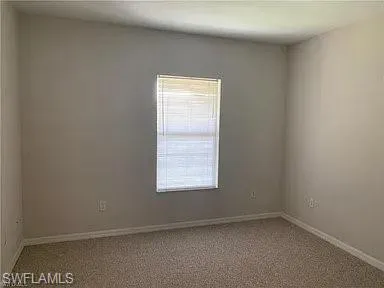 Unfurnished room with carpet and baseboards