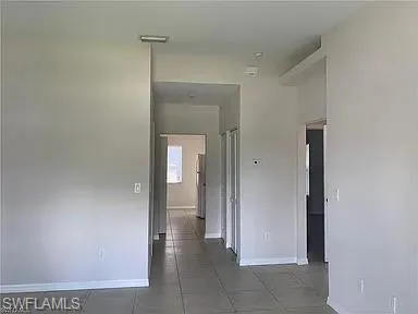 Corridor with tile patterned floors and baseboards
