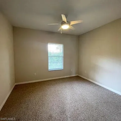 Empty room with a ceiling fan and baseboards