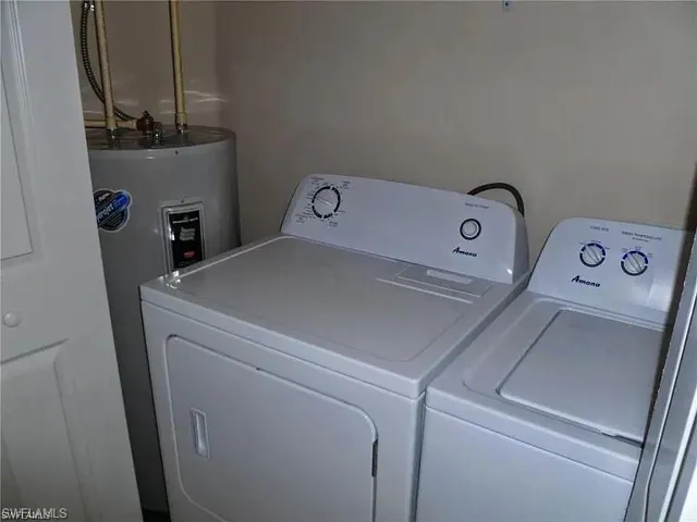 Laundry room featuring washer and dryer and electric water heater
