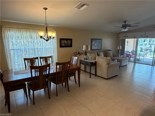 Dining area featuring a chandelier, a ceiling fan, and light tile patterned floors
