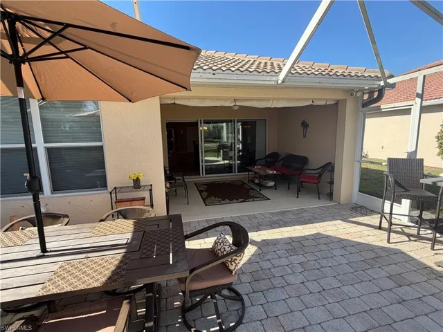 View of patio / terrace featuring outdoor dining space, a sunroom, and glass enclosure