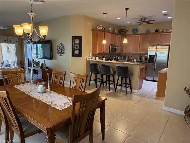 Dining space featuring a ceiling fan, a chandelier, light tile patterned floors, and recessed lighting
