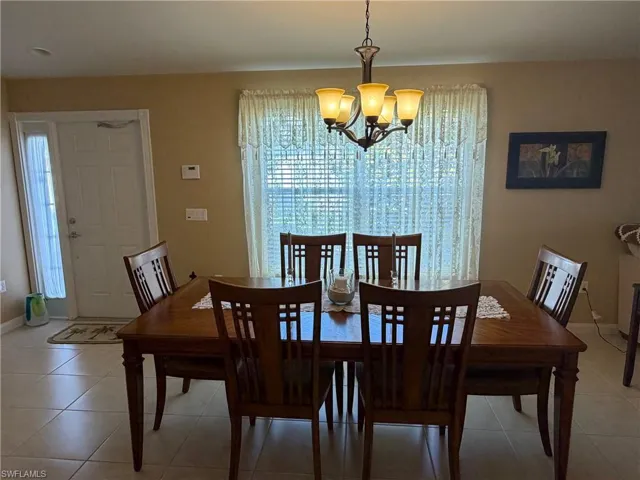 Dining space with a chandelier and light tile patterned flooring
