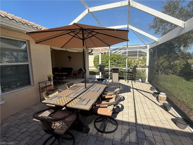 View of patio featuring outdoor dining area, a lanai, and a sunroom