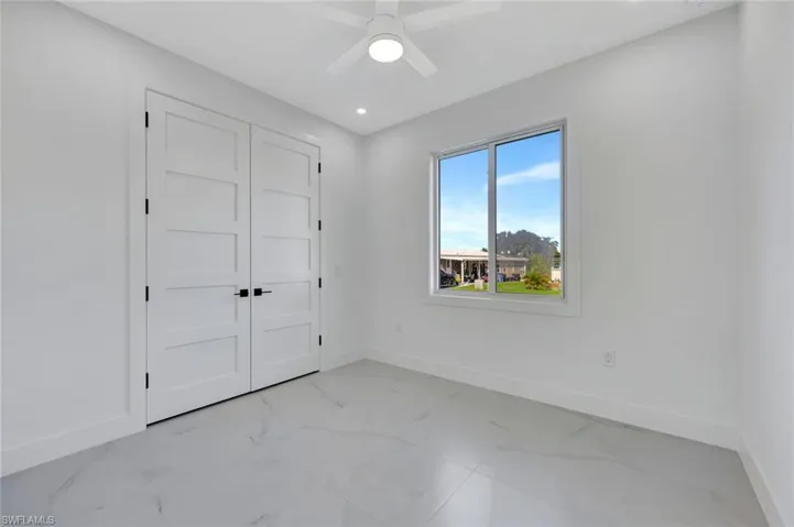 Spacious second bedroom features double doors.