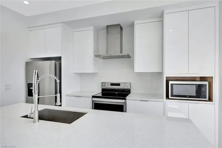 Kitchen features stainless Whirlpool appliances and modern cabinets.