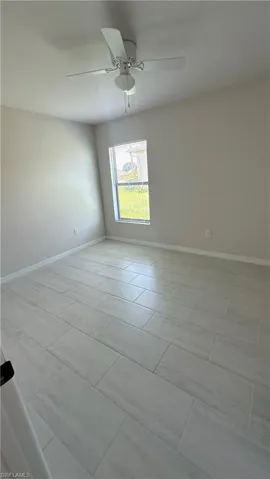 Spare room featuring baseboards and ceiling fan