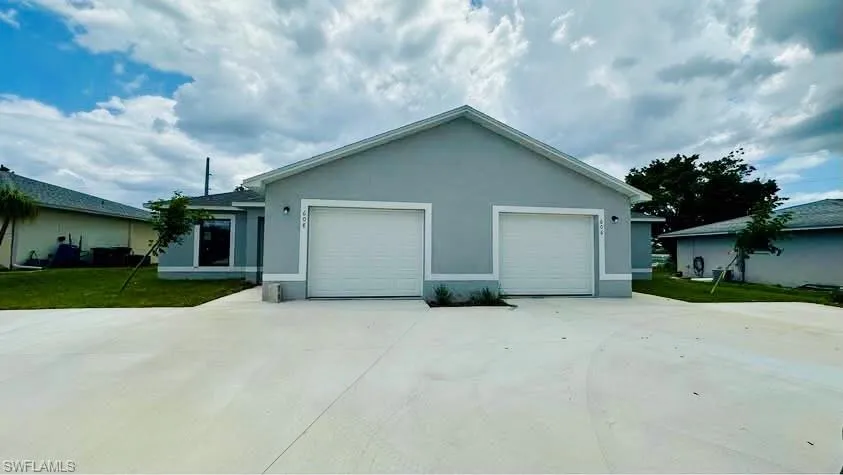 View of home's exterior with stucco siding, concrete driveway, an attached garage, and a lawn