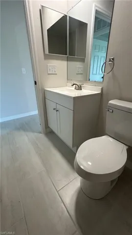 Half bathroom featuring vanity and toilet