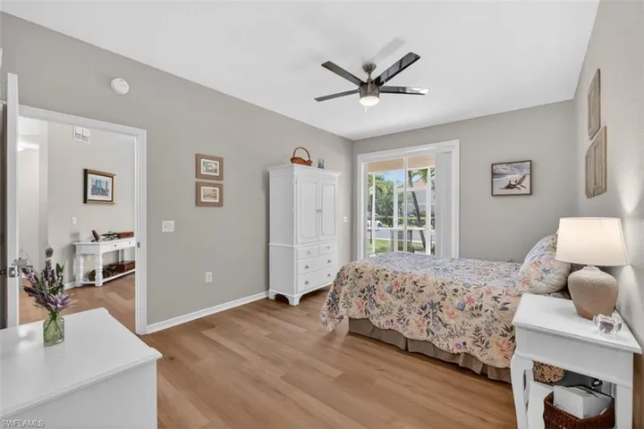 Bedroom with light wood finished floors, access to outside, and a ceiling fan