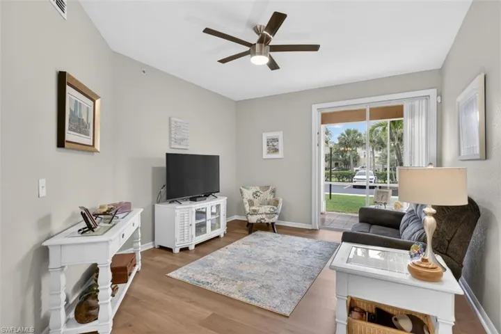 Living area with ceiling fan and light wood finished floors