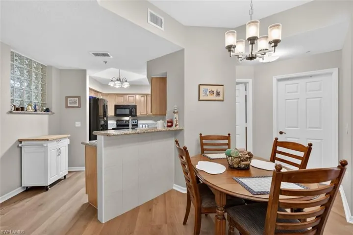 Dining room with hanging lights and light wood-style floors