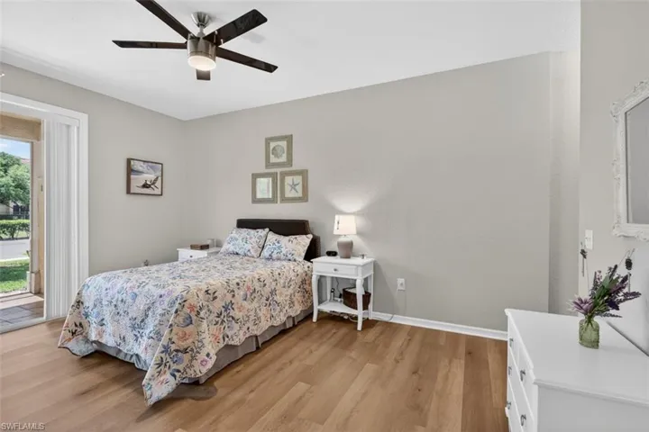 Bedroom with access to exterior, light wood-type flooring, and a ceiling fan