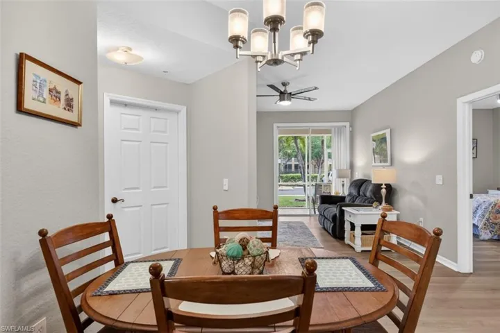 Dining area with suspended lighting, ceiling fan, and light wood-style flooring
