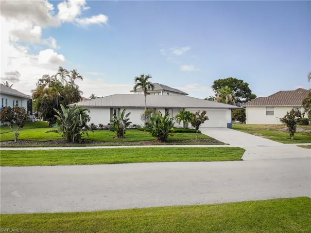 Single story home featuring a garage and a front lawn