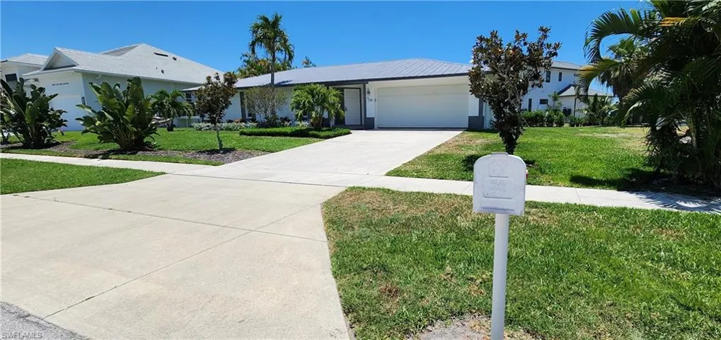 Ranch-style home with a front lawn and a garage